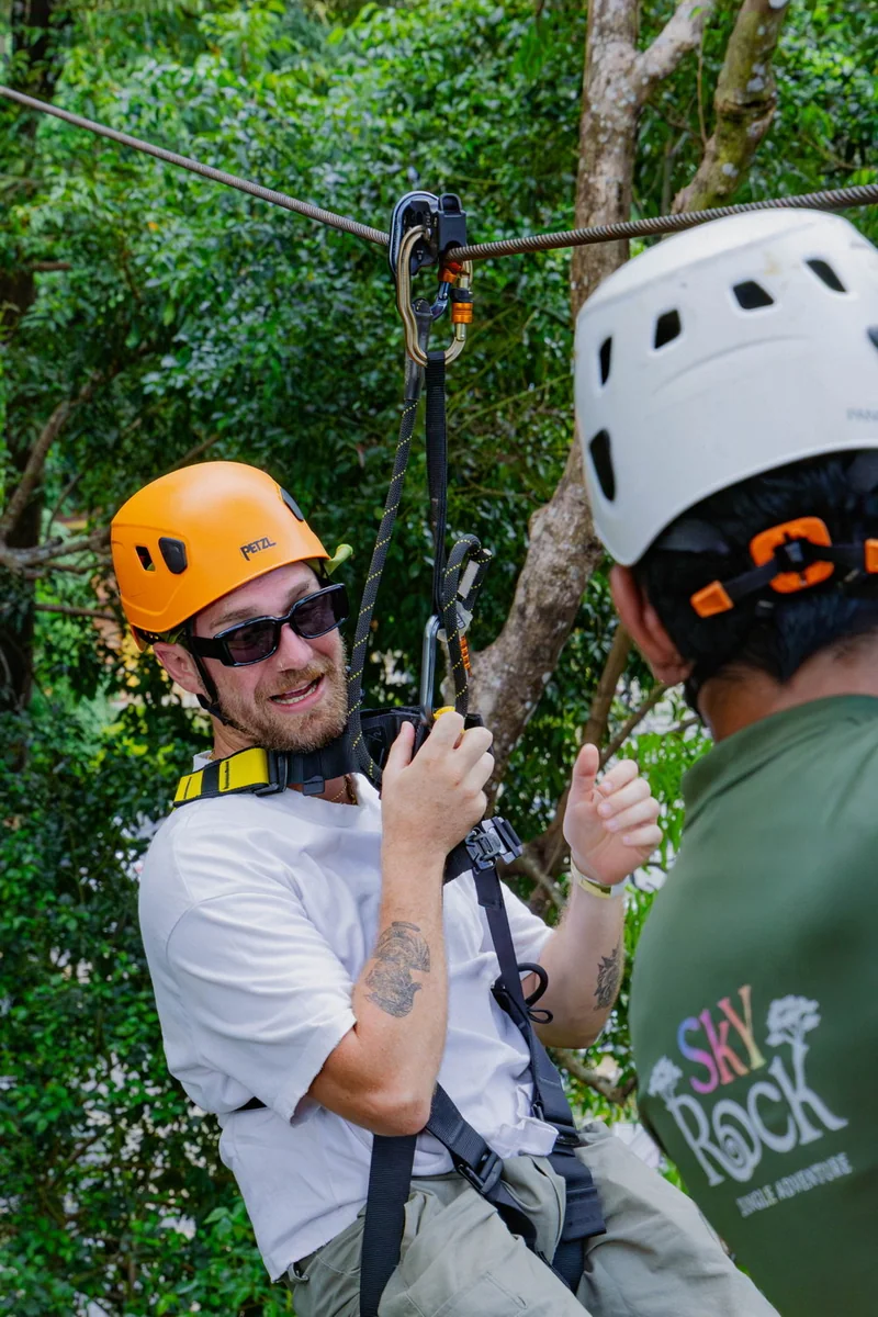 Helmeted staff member and participant together beside equipment on a platform