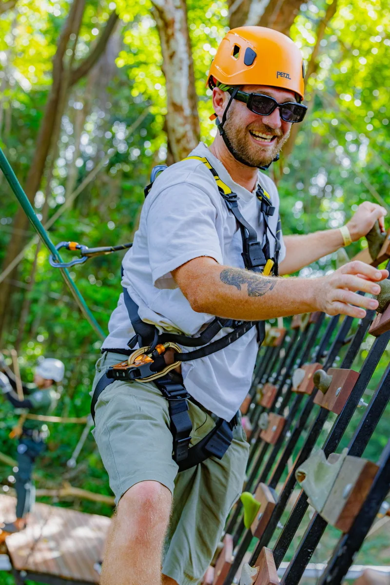 Helmeted participant in a light shirt and shorts on an elevated activity